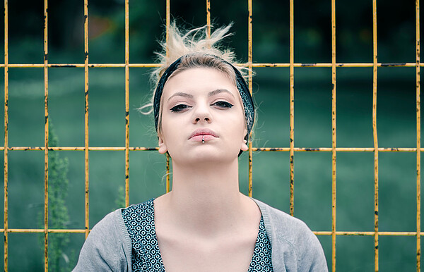 Young,Teenage,Girl,Posing,On,Fence