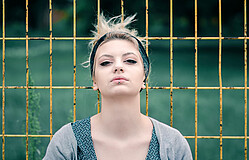 Young,Teenage,Girl,Posing,On,Fence
