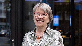 Petra Merkel lächelt ins Bild, trägt eine rote Brille